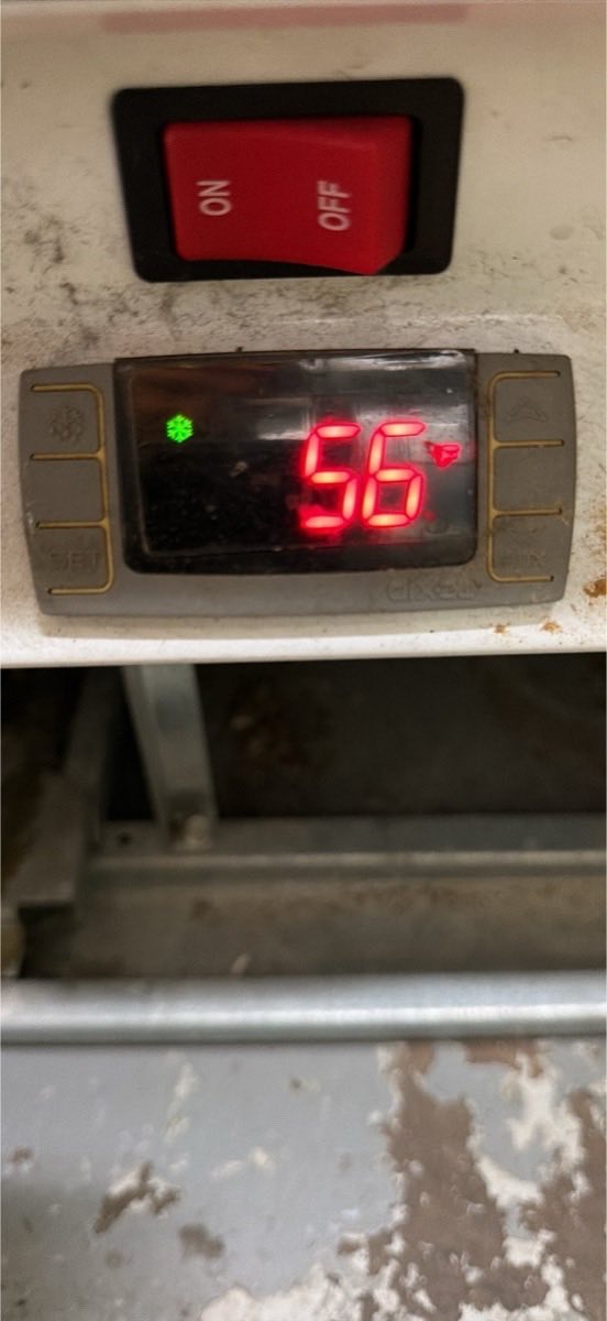 Commercial refrigeration controller display reading 56 degrees Fahrenheit with the cooling indicator lit