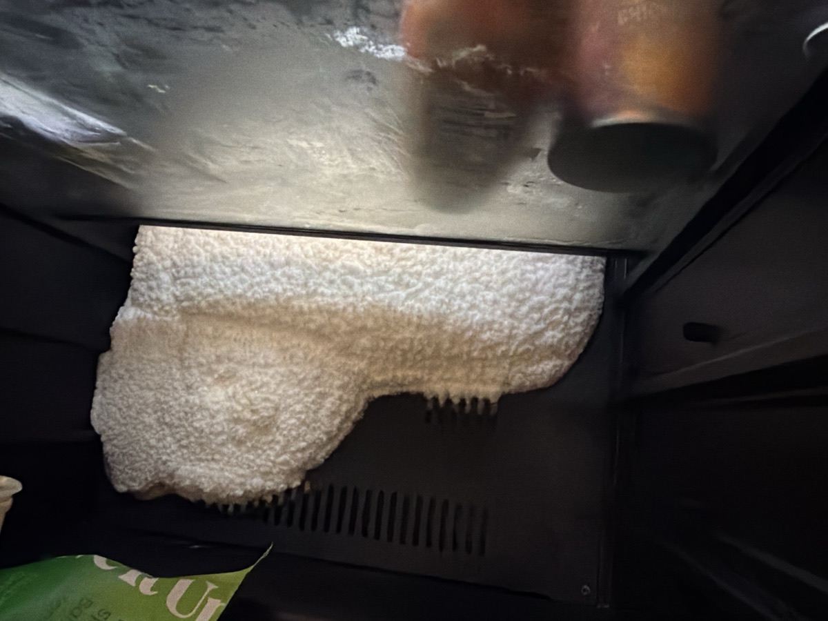 Block of ice built up under a freezer panel where defrost water refroze