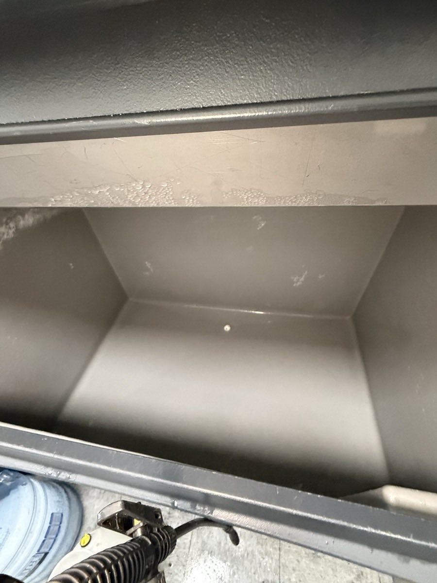 Empty commercial ice machine storage bin during a service call