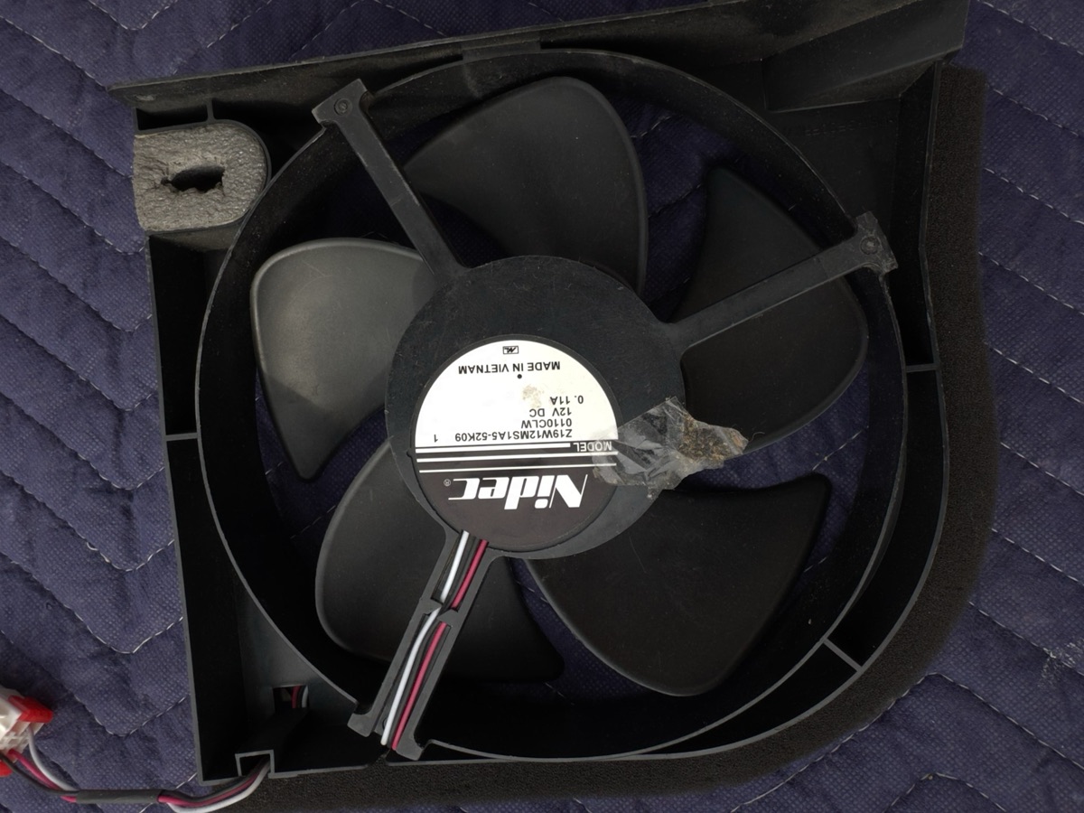 Refrigerator evaporator fan assembly removed for testing, resting on a moving blanket