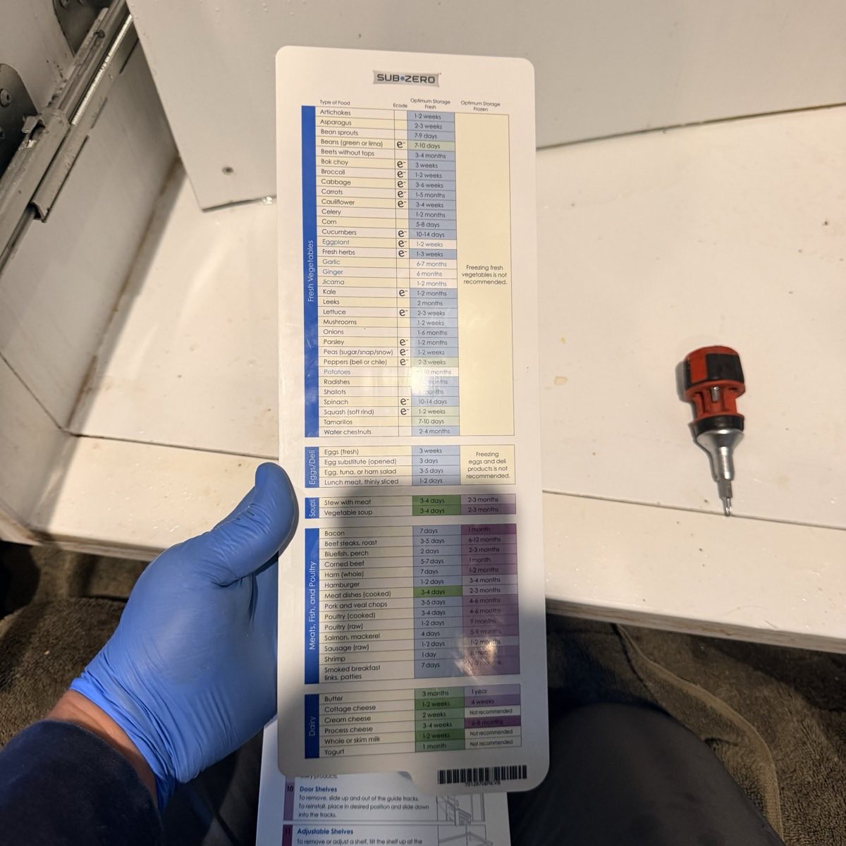 Sub-Zero branded food storage guide card removed from a built-in refrigerator during a service call