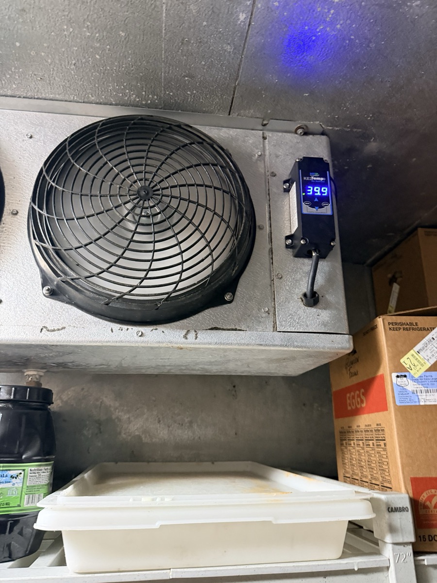 Walk-in cooler evaporator fan with a digital controller reading 39.9 degrees